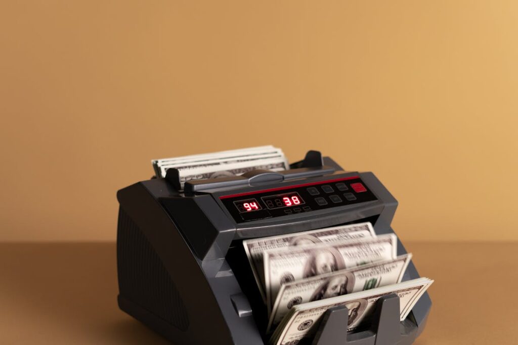 Counting machine tallying hundred-dollar bills