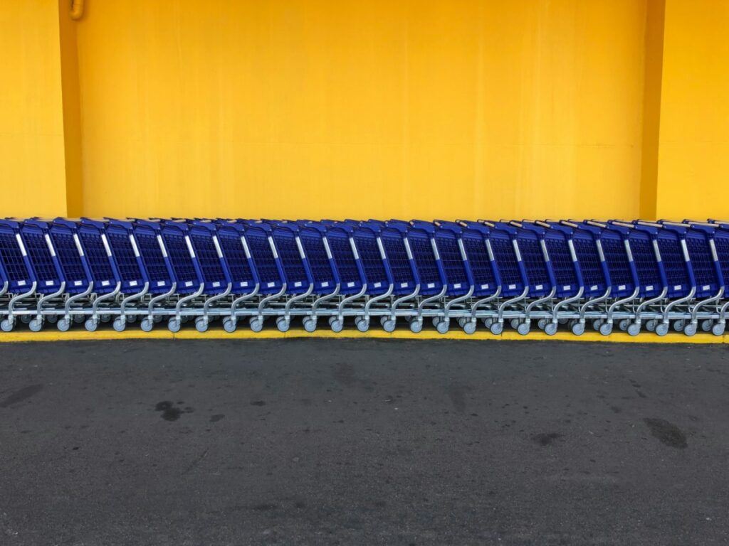 Walmart-style blue shopping carts against a yellow wall